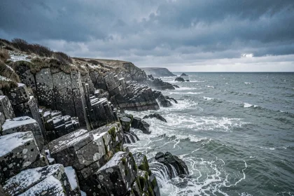 Côte sauvage du Finistère en hiver avec rochers granitiques et mer agitée sous ciel nuageux