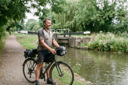 Homme en vélo de route au bord d'un canal paisible